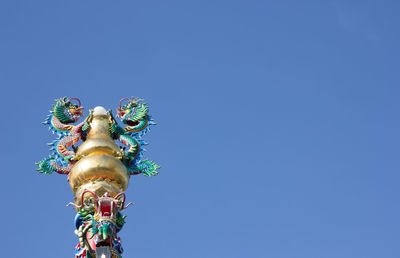 Low angle view of statue against blue sky