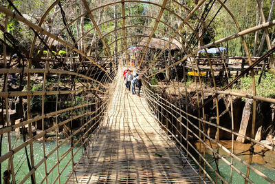 Woman walking on footpath by footbridge