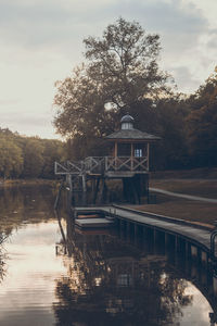 View of hut by lake against sky