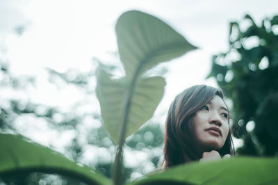 Low angle view of young woman looking away