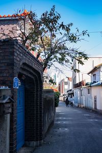 Street amidst buildings against blue sky