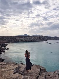 Silhouette of woman standing in front of lake