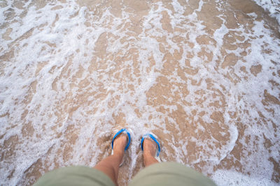 Low section of person standing on beach