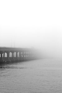 Bridge over sea in foggy weather