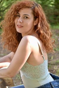 Portrait of beautiful young woman sitting outdoors