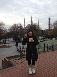 Portrait of smiling young woman standing in city