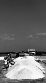 People in snow against sky during winter