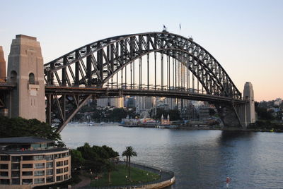 Syndney harbour bridge over river in city against clear sky