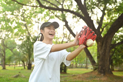 Side view of young woman holding apple