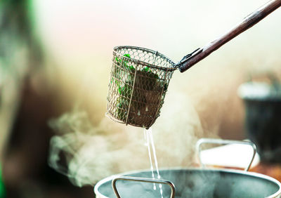 Food in container over hot kitchen utensil