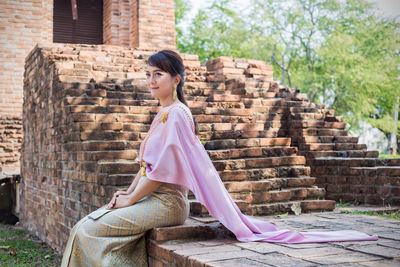 Side view of woman sitting outdoors