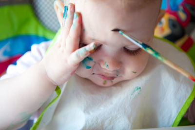 Close-up of cute baby girl holding paintbrush at home