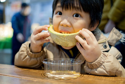 Portrait of boy eating food at restaurant