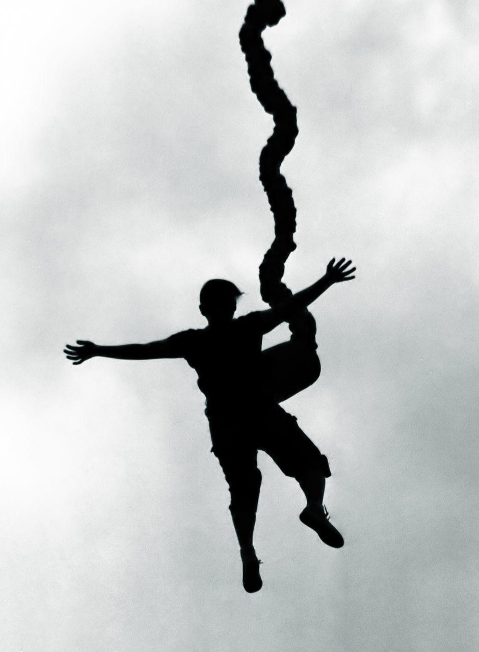 SILHOUETTE OF MAN JUMPING AGAINST SKY