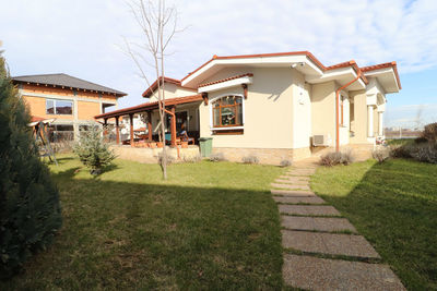 Houses on field by lawn against sky