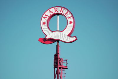 Low angle view of sign against clear blue sky