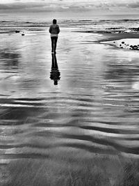 Rear view of man standing on beach