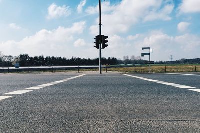 Empty road against cloudy sky