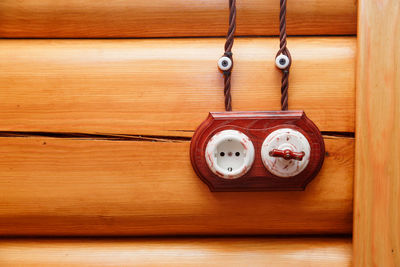 Close-up of electrical outlet on wooden wall