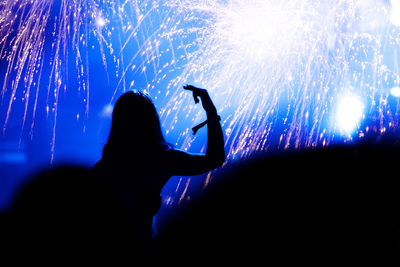 Crowd at music concert against firework during night