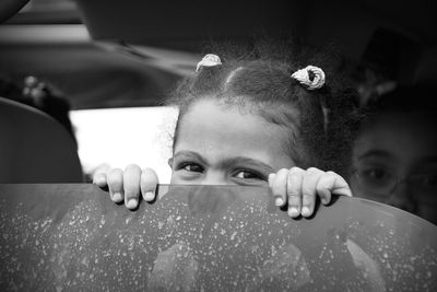 Portrait of girls hiding by wall