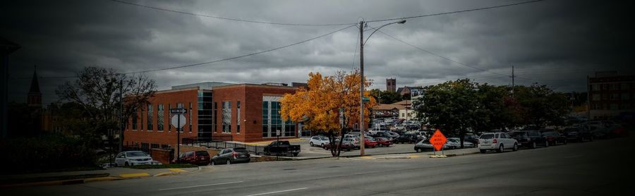 Cars on roadside against cloudy sky