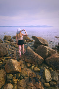 Beautiful young girl in the hat standing on the rocky coast of wild atlantic way at barna 