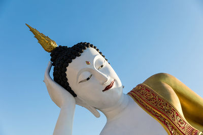 Close up face of reclining buddha statue at phra that doi kham temple in chiang mai, thailand