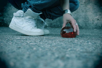 Low section of man playing with ball on street