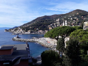 High angle view of townscape by sea against sky