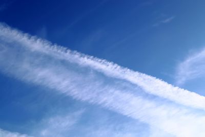 Low angle view of vapor trail against blue sky