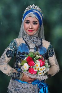 Portrait of young woman holding flower bouquet