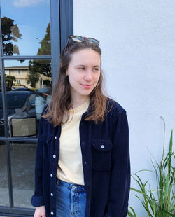 Beautiful young woman looking away while standing outdoors