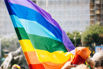 Cropped image of woman with rainbow flag during gay pride parade