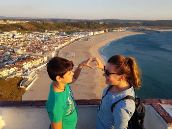 High angle view of boys and sea against cityscape