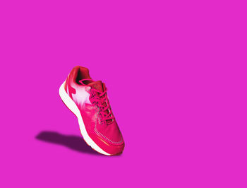 Close-up of shoes on pink background