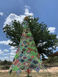 Low angle view of trees on field against sky