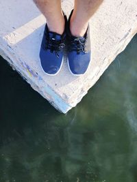 Low section of person standing in water