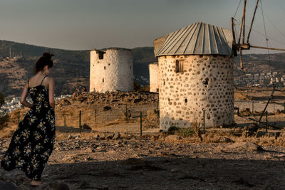 Man standing by old building against sky