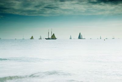 Sailboats sailing in sea against sky