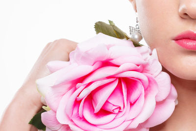 Close-up of woman with roses against white background