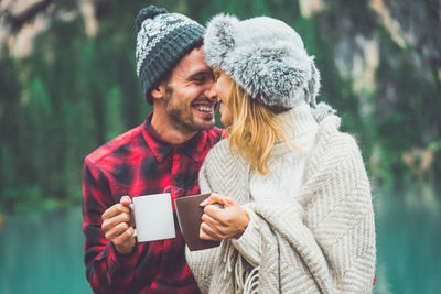 Portrait of smiling man drinking coffee during winter