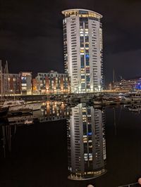 Illuminated buildings against sky at night