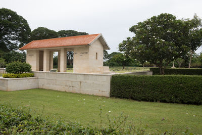 House on field by lawn against sky