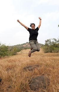 Full length of woman jumping on land