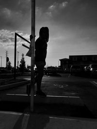 Full length of boy standing in city against sky