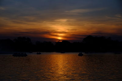 Scenic view of lake against orange sky