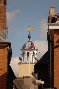 British flag by historic building against sky