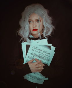 Portrait of woman holding paper with text
