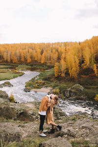 Happy people in love are travel hike in nature in the autumn forest. romantic trip to countryside